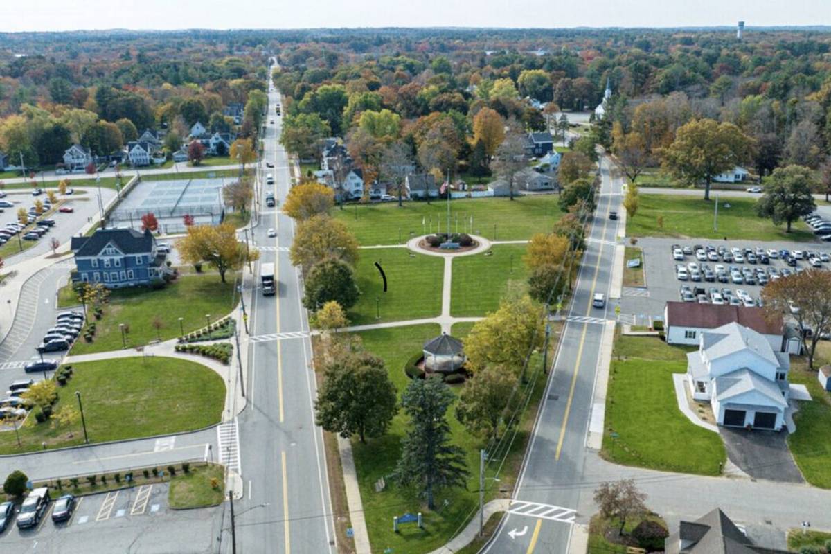 Aerial view of the town common with a gazebo, a main road and fall trees around homes in Wilmington MA