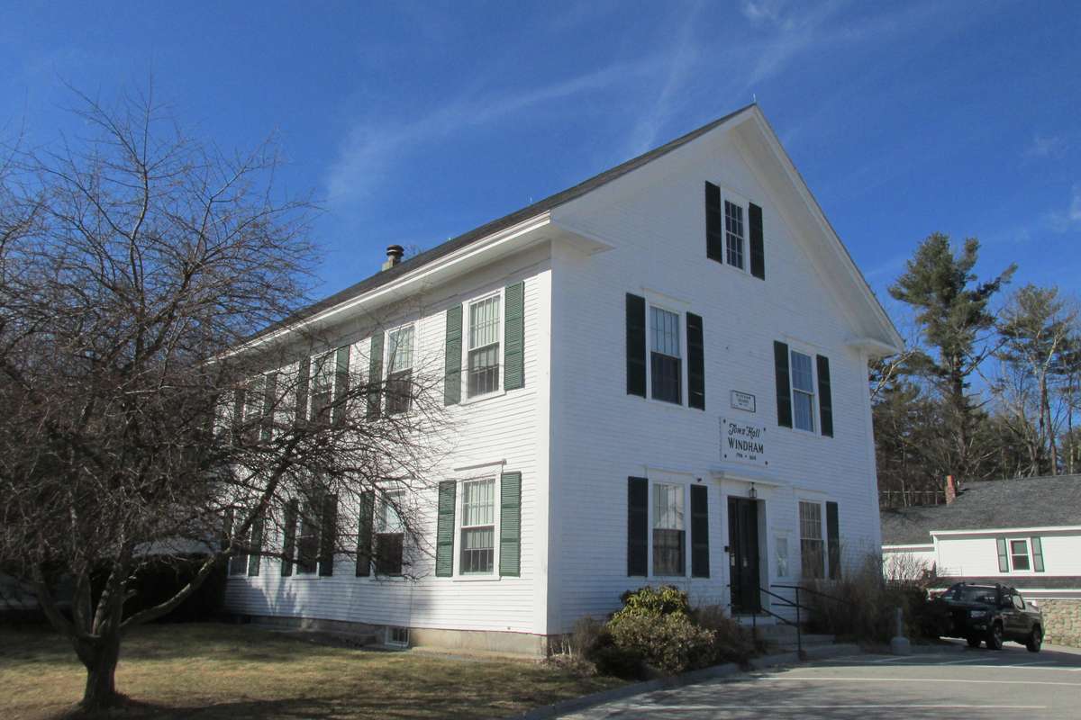 The white historic town hall building in Windham NH on a clear day