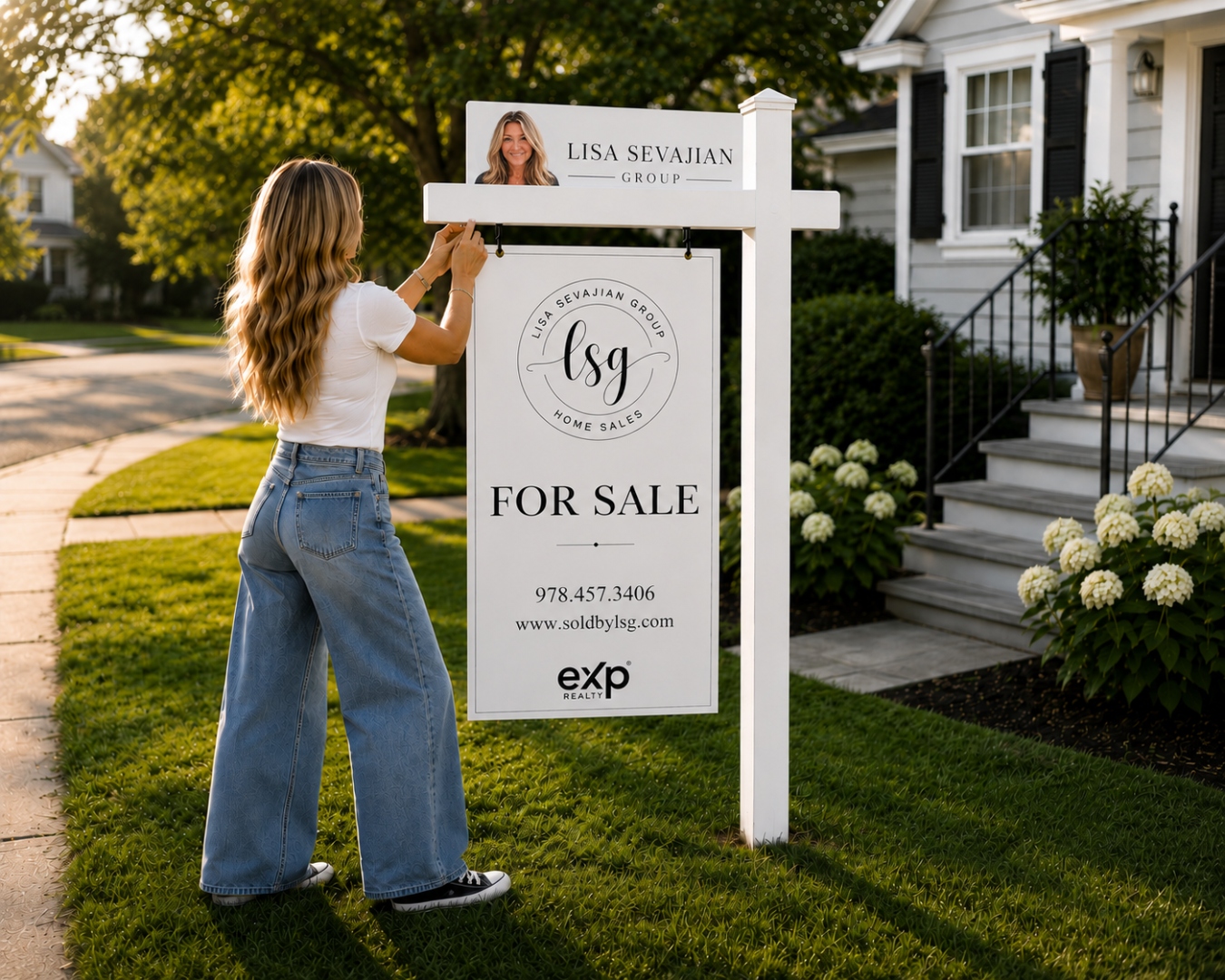 Lisa Sevajian hanging a For Sale sign in a client's yard