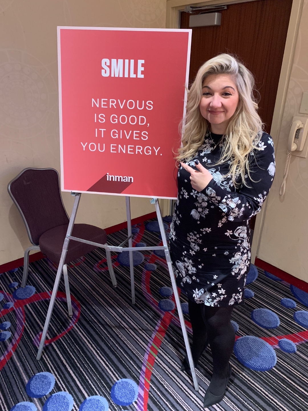 Lisa Sevajian at Inman Connect standing beside an easel that reads Smile - Nervous is good, it gives you energy.