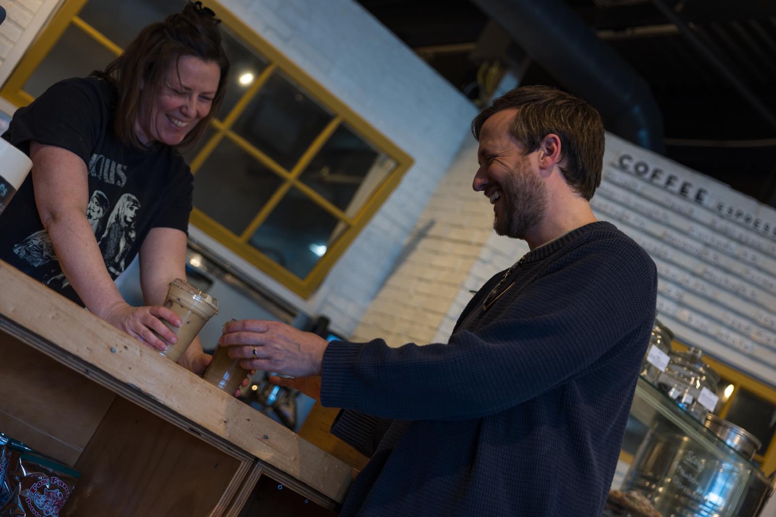 Steve laughing with a barista over coffee