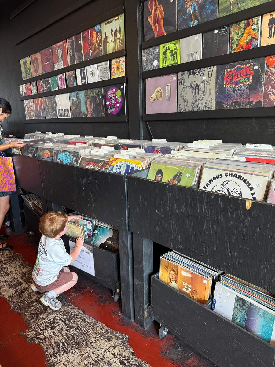 A toddler flipping through the bottom bin of a record store