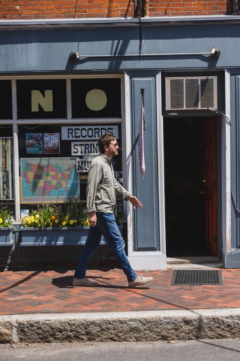 Steve Wallace walking past a record shop window in Newburyport MA